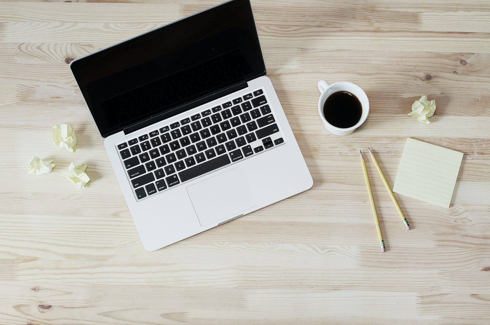 Laptop e café sobre uma mesa de trabalho